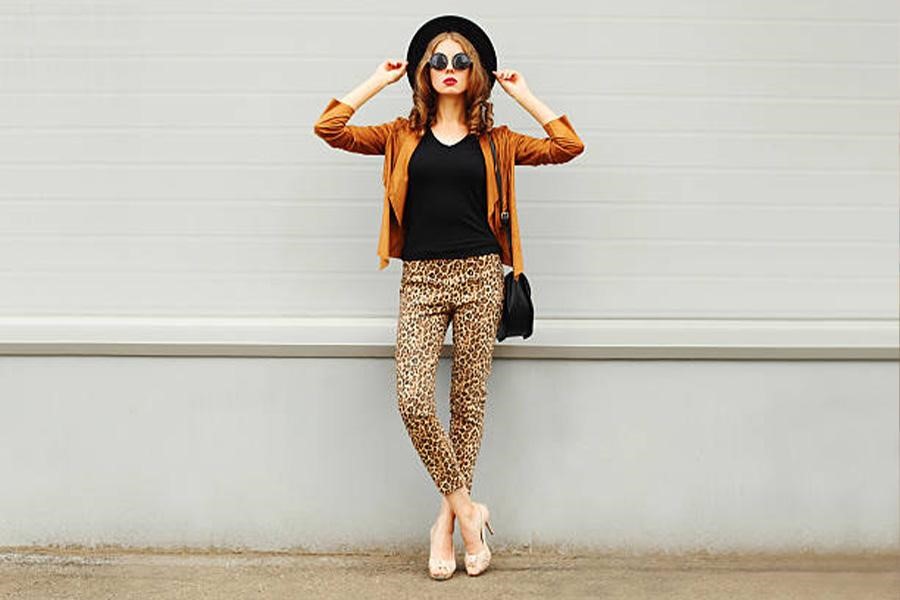 Woman wearing animal print pants with black T-shirt and bag