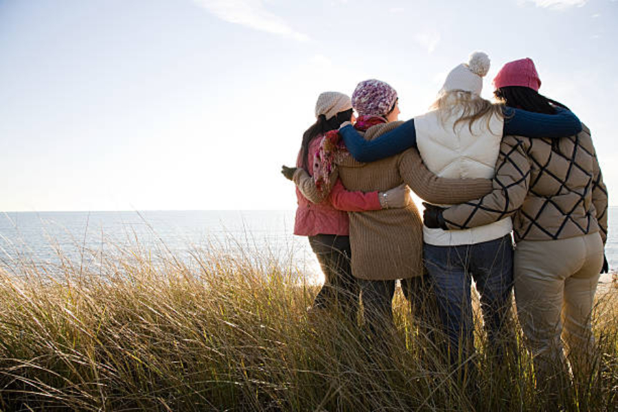 A group of women near sea wearing different winter hats