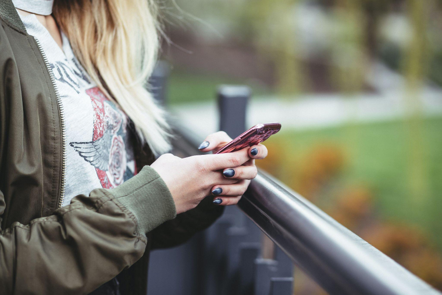 Woman with black and white ombre nails holding cell phone